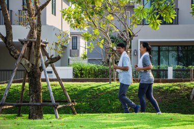Birkaç yaşlı Asyalı erkek ve kadın sabah egzersizlerinden önce egzersiz kıyafeti giyerler. Sabah sabah bahçede koşan erkekler ve kadınlar..