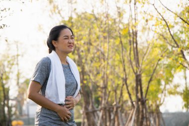 Yaşlı Asyalılar egzersiz ağrısından muzdaripti. Yaşlı kadın mide ağrısından muzdaripti..