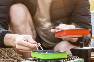 Genç çift kamp yaparken kahve içip gitar çalıyor.