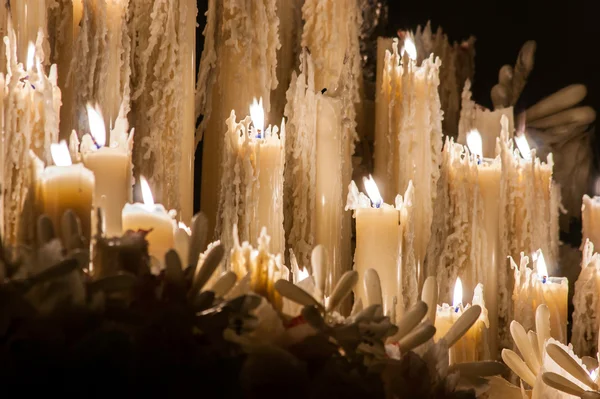 Some burning wax candles that are melted in the Holy Week of Seville.