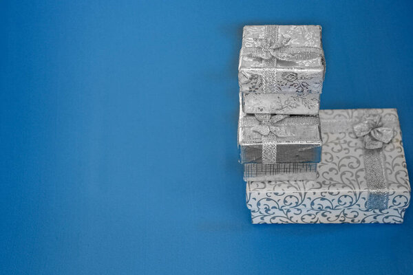 серебряные подарочные коробки на синем фоне. серебряные шкатулки W