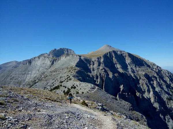 Olimpos Dağı 'nın zirvesine giden dik yolda sırt çantasıyla yürüyen yürüyüşçü _ Yunanistan