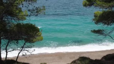 Yunanistan 'ın Corinth kenti yakınlarındaki çam ağaçlarının arasından dalgalar ve turkuaz deniz manzarası