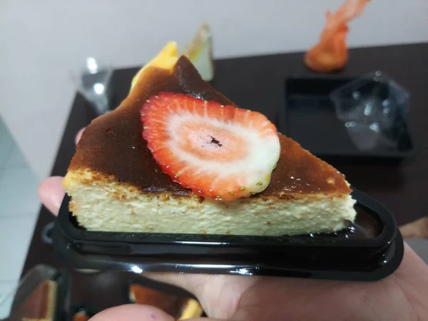 Pedaço Cheesecake Com Morango Mão Fundo Desfocado — Fotografia de Stock