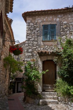 Eze, Fransa - 17 Haziran 2021 - güneşli bir bahar öğleden sonra Fransız Rivierası tepelerinde bir ortaçağ kasabası - sokaklar ve antik köşelerinden oluşan labirentinde yürür.                               