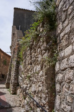 Eze, Fransa - 17 Haziran 2021 - güneşli bir bahar öğleden sonra Fransız Rivierası tepelerinde bir ortaçağ kasabası - sokaklar ve antik köşelerinden oluşan labirentinde yürür.                               