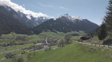 Neustift, Avusturya - 19 Nisan 2025 - Karla kaplı dağlarla kaplı bir vadide yuva yapmış bir köyün manzarası