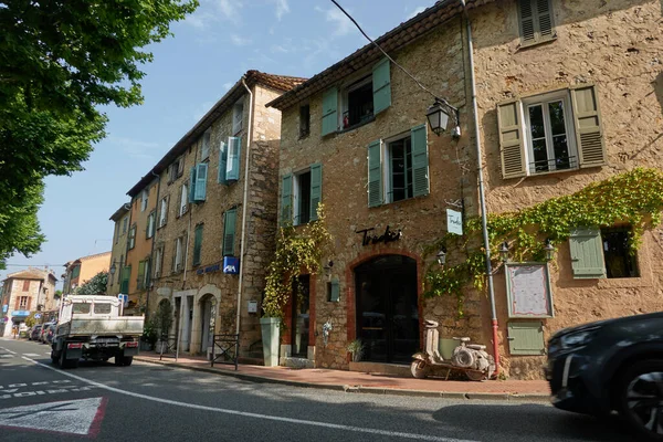 Valbonne, Fransa - 13 Haziran 2025 - Sarmaşıklı ve sessiz bir caddeye park edilmiş siyah arabalı hoş bir taş bina                               