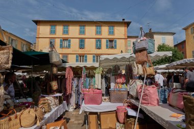 Valbonne, Fransa - 13 Haziran 2025 - Renkli tekstil ürünleri ve alışveriş yapanlarla açık hava pazarı                               