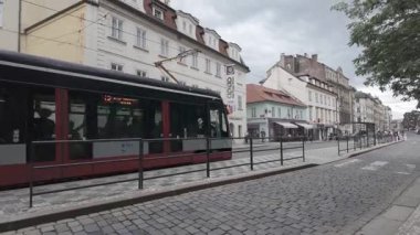 Prag, Çek Cumhuriyeti - 5 Temmuz 2024 - Modern tramvay tarihi binaları olan bir Avrupa şehrinde kaldırım taşı caddesi boyunca seyahat ediyor
