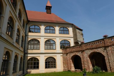 Brno, Çek Cumhuriyeti - 16 Ağustos 2025 - Veveri Kraliyet Kalesi - Güneşli bir günde uzun silindirik kulesi ve kemerli pencereleri olan tarihi kale avlusu