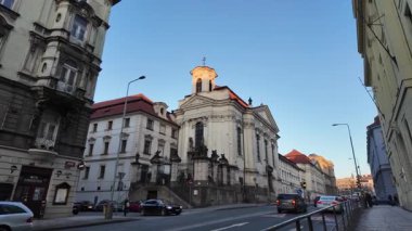 Prag, Çek Cumhuriyeti - 19 Ocak 2026 - St. Cyril ve Methodius Ortodoks Katedral Kilisesi - Barok kilise cephesi güneşli bir günde süslü detaylar ve arabalarla geçen