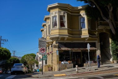 San Francisco, ABD - 28 Ekim 2025 - San Francisco Viktorya dönemi mimarisi dik bir tepede park etmiş arabalarla ve açık mavi gökyüzüyle