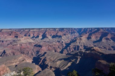 Büyük Kanyon, ABD - 20 Ekim 2025 - Açık mavi gökyüzü altında Geniş Büyük Kanyon manzarası, katmanlı kaya oluşumları ve derin gölgeler