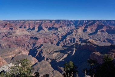 Büyük Kanyon, ABD - 20 Ekim 2025 - Açık mavi gökyüzü altında Geniş Büyük Kanyon manzarası, katmanlı kaya oluşumları ve derin gölgeler