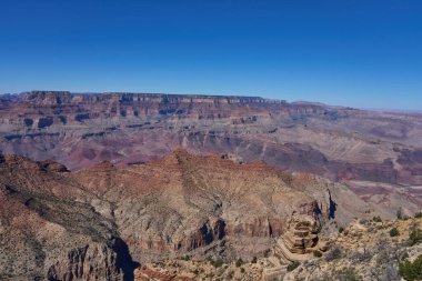 Büyük Kanyon, ABD - 20 Ekim 2025 - Açık mavi gökyüzü altında katmanlı kaya oluşumları ile genişletici Büyük Kanyon manzarası