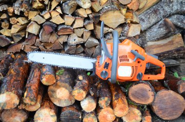 Elektrikli testere ve yakacak odun resmi.