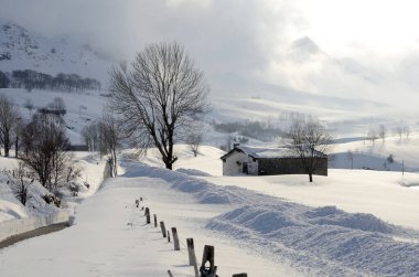 Valle del Pas 'taki (Valles Pasiego) çayırları ve çoban kulübelerini kar kaplar. Cantabria, İspanya