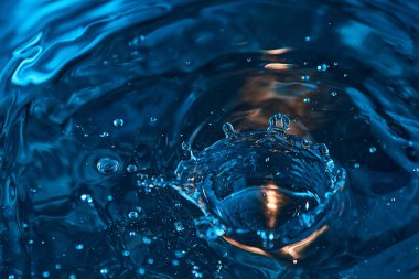 Renkli bir arka planda su damlaları ve dalgalar. İnanılmaz doğal su arka plan dokusu.