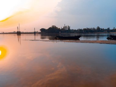 Nehirdeki tekne gökyüzü arka planında