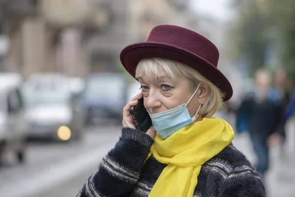 Μια Ηλικιωμένη Γυναίκα Ετών Ιατρική Μάσκα Μιλάει Στο Τηλέφωνο Φόντο — Φωτογραφία Αρχείου