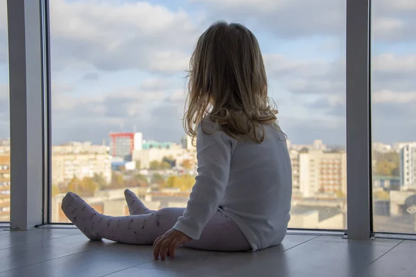 Uma Menina Senta Chão Apartamento Frente Enormes Janelas Olha Para — Fotografia de Stock