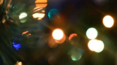 Noel ışıkları parlıyor ve sönüyor. Yapay Noel ağaçları üzerindeki parlak ve renkli süslemeler..