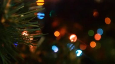 Noel ışıkları parlıyor ve sönüyor. Yapay Noel ağaçları üzerindeki parlak ve renkli süslemeler..