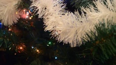 Noel ışıkları parlıyor ve sönüyor. Yapay Noel ağaçları üzerindeki parlak ve renkli süslemeler..