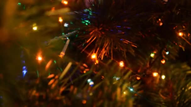 クリスマスライトは 人工的なクリスマスツリー上でライトアップされ 外出し 焦点を合わせ 明るくカラフルな装飾 — ストック動画