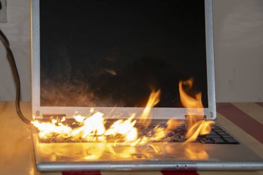 Masanın üstündeki odada dizüstü bilgisayar alev aldı, pilin ve lenslerin ateşlenmesi, kısa devre. Yangın güvenlik sistemi.