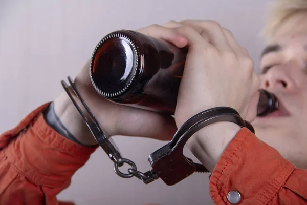 Adolescent Menotté Boit Une Bouteille Bière Sur Fond Gris Gros — Photo