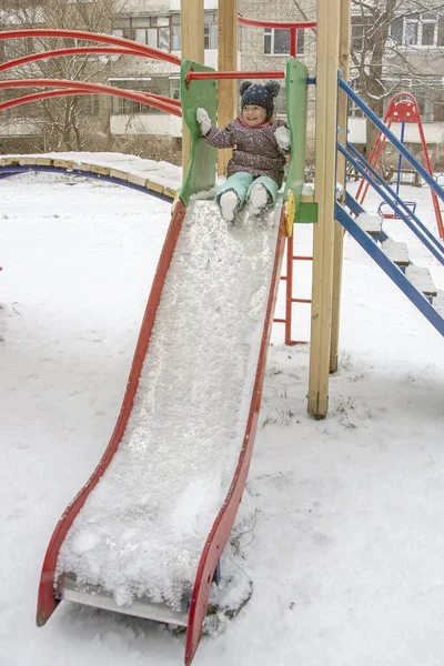 Ein Kleines Mädchen Rutscht Winter Auf Einem Spielplatz Eine Rutsche — Stockfoto