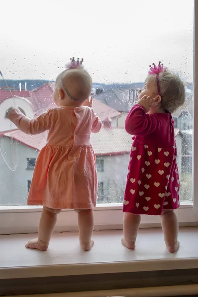 Kafalarında Çocuk Süsleri Olan Iki Küçük Kız Pencere Eşiğinde Durup — Stok fotoğraf