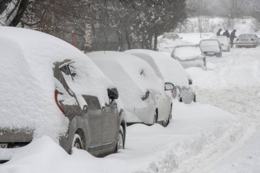 Park etmiş arabalar, karla kaplı, yol kenarında dururlar. Şehirde kar yağışı, düşen kar taneleri. Kavram: trafik çöküşü, artan yağış ve kar seviyesi, kar fırtınaları ve kar akıntıları.