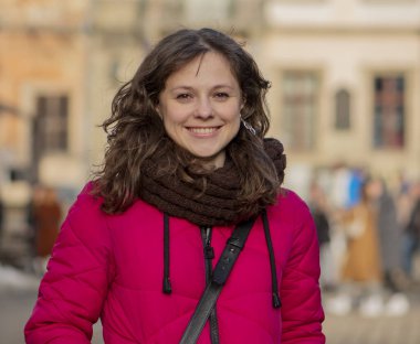 Narin hatları olan neşeli, başarılı orta yaşlı bir kadının sokak portresi. 30-35 yaşlarında bir kadın, ev hanımı ya da bilişim uzmanı gibi görünen bir kadın, bir turizm alanının müdürü ya da bir alışverişçi..