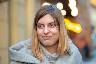 25-30 yaşlarında, hoş beyaz bir kadın. Sarı saçlı, bulanık bir şehir geçmişi var..