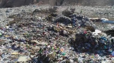 Açık şehir çöplüğünün en üst görüntüsü. Kuşlar uçar, buldozer seviyesinde çöp yığınları, hava fotoğrafçılığı. Kavram: şehrin çevresel sorunları, insan atıklarının imhası için atık alanları.