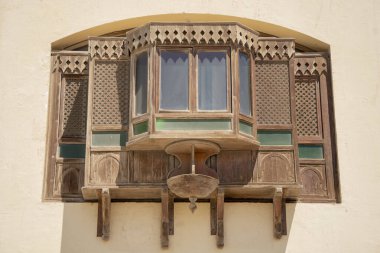 Doğu tarzında oyulmuş ahşap pencereli binanın ön cephesinin bir parçası, küçük bir kafes.,