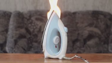 Dairedeki ütü ütüsünün yanması, kıvılcımlar hatalı kablolar, kısa devre. Kavram: evdeki yangının nedeni, uzun bir süre elektrik cihazları ağına bağlı kalmış..