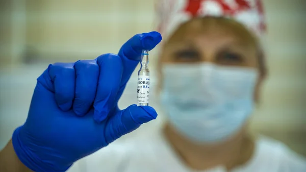 医師は彼の手袋にコロナウイルスからロシアのワクチン スプートニク の小瓶を保持しています 集団予防接種 病気に対する予防接種 ロシア モスクワ 2021年5月11日 — ストック写真