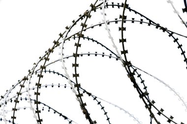 Beyaz arka planda askeri dikenli teller, izole. Kavram: Demir Perde, işgal rejimi, giriş ve çıkış yasağı, özgürlük kısıtlaması.