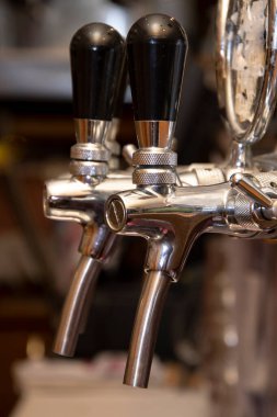 Barın arkasındaki barda bira doldurmak için elle dokunmatik pompa..