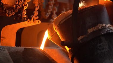 Erimiş metalle dolu bir kaseden çelik endüstrisine küfler dökülüyor..