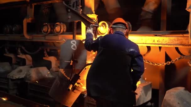 鋼労働者は鋼業界の金型にるつぼから溶融金属を注ぎ コンベアが動きます — ストック動画