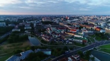 Minsk 'in merkezindeki şehir merkezinden panoramik bir manzara, bir gökdelenin camı, yükselen güneşin yansıması, Pobediteley Bulvarı, Svisloch Nehri.