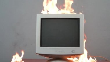Eski bir bilgisayar monitörü yanıyor. Evdeki yangın tehlikesi, yangın nedenleri, kısa devre..