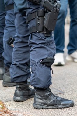 Şehirdeki bir polis memurunun botları ve taktik pantolonu.