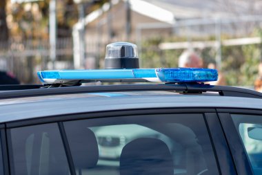 Şehir caddesinde bir polis arabasının çatısına mavi bir ışık konur.