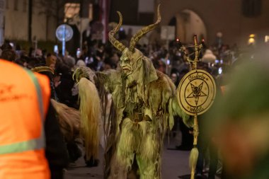 Krampus büyük bir kostüm içinde Avusturya, Graz, 16 Kasım 2025 'te bir şenlik geçidi sırasında sokakta yürür..